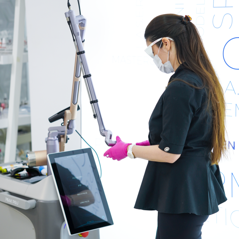 Cursantă a Colegiului de Estetică setând parametrii unui aparat laser profesional